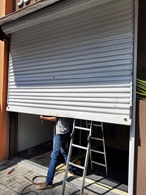 Conserto da fita lateral da porta de enrolar de aço em comércio e loja em geral.