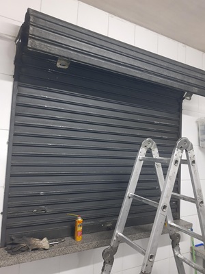 Conserto de porta de enrolar com troca de mola em Curitiba
